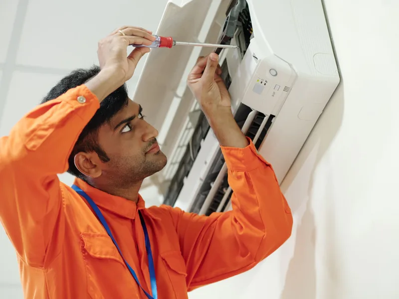 Home services technician servicing an air conditioner